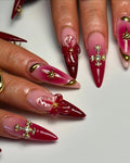Handmade red and pink stiletto press-on nails with 3D floral, gold celestial, and cross art designs