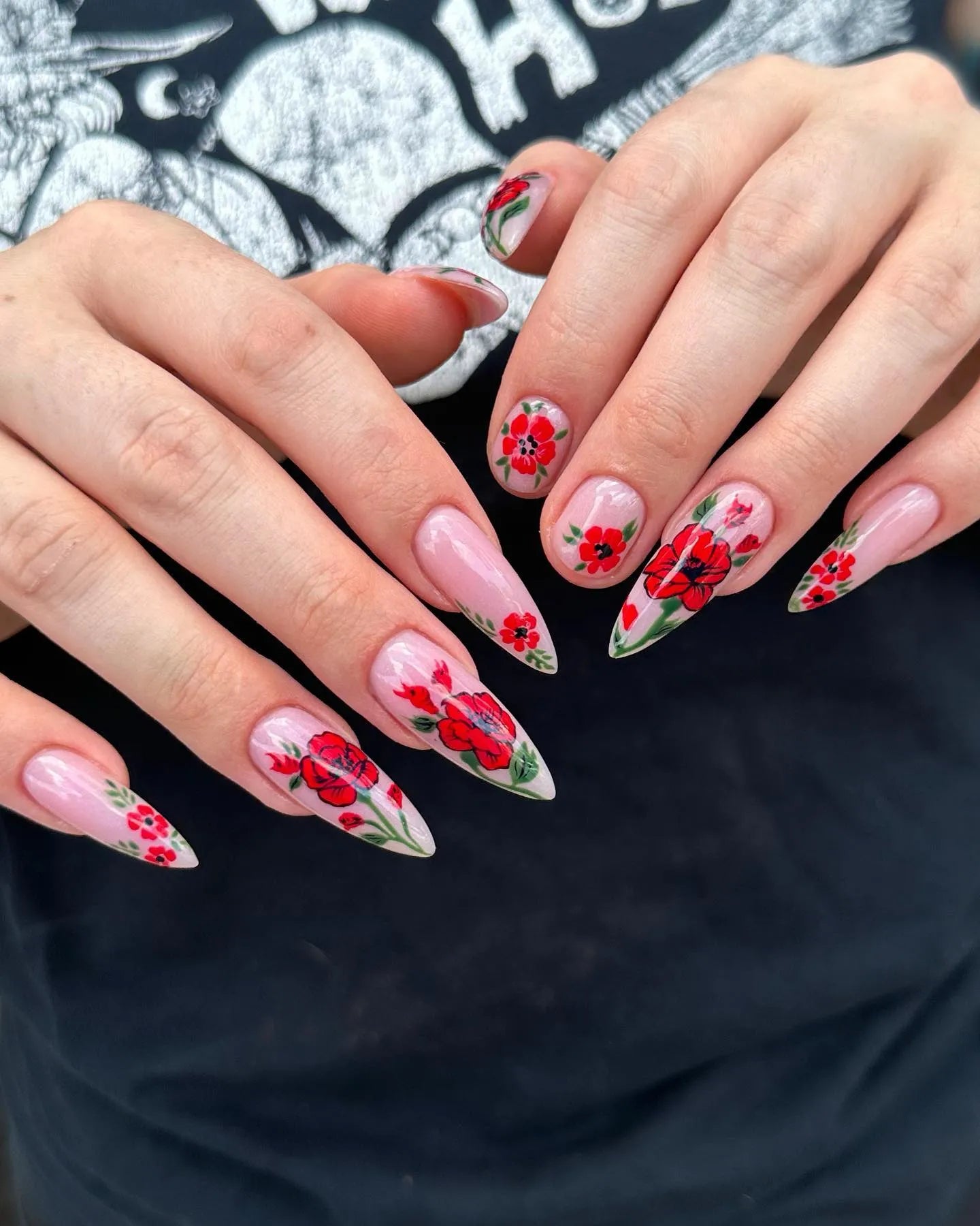 Long stiletto press-on nails with handmade red poppy floral garden nail art.