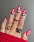 Hand with almond-shaped press-on nails featuring handmade red strawberry fruit art design