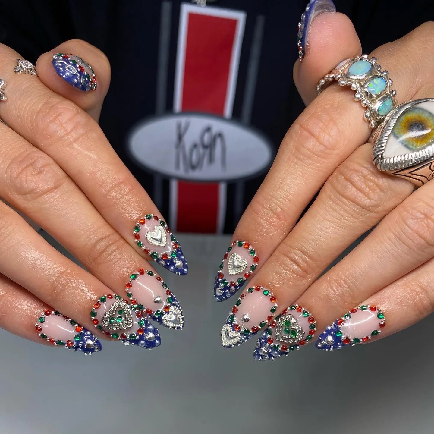 Handmade royal blue ombre heart press-on nails with colorful chrome gemstones.