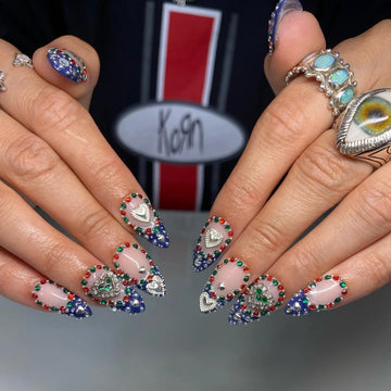 Handmade royal blue ombre heart press-on nails with colorful chrome gemstones.