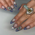 Handmade royal blue ombre press-on nails with heart charms, rhinestones, and gemstone details.