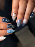 Handmade royal blue shimmer press-on nails with starburst, pearl, and 3D charm accents.