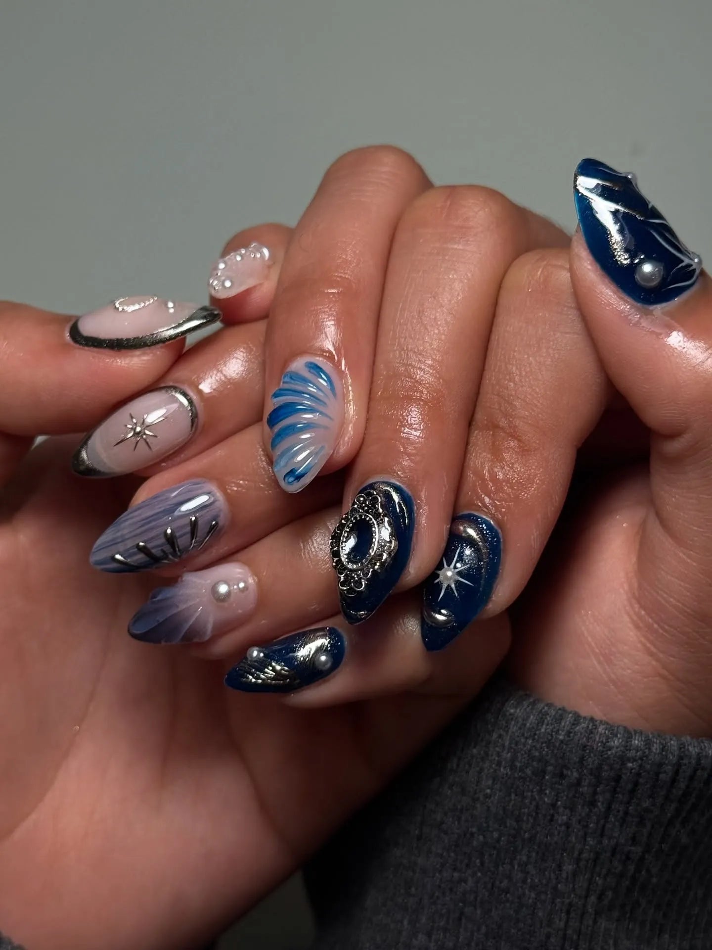 Handmade royal blue shimmer press-on nails with 3D pearl, silver starburst, and charm accents.