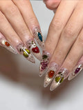 Handmade stiletto press-on nails with gemstone fruit designs and gold filigree accents
