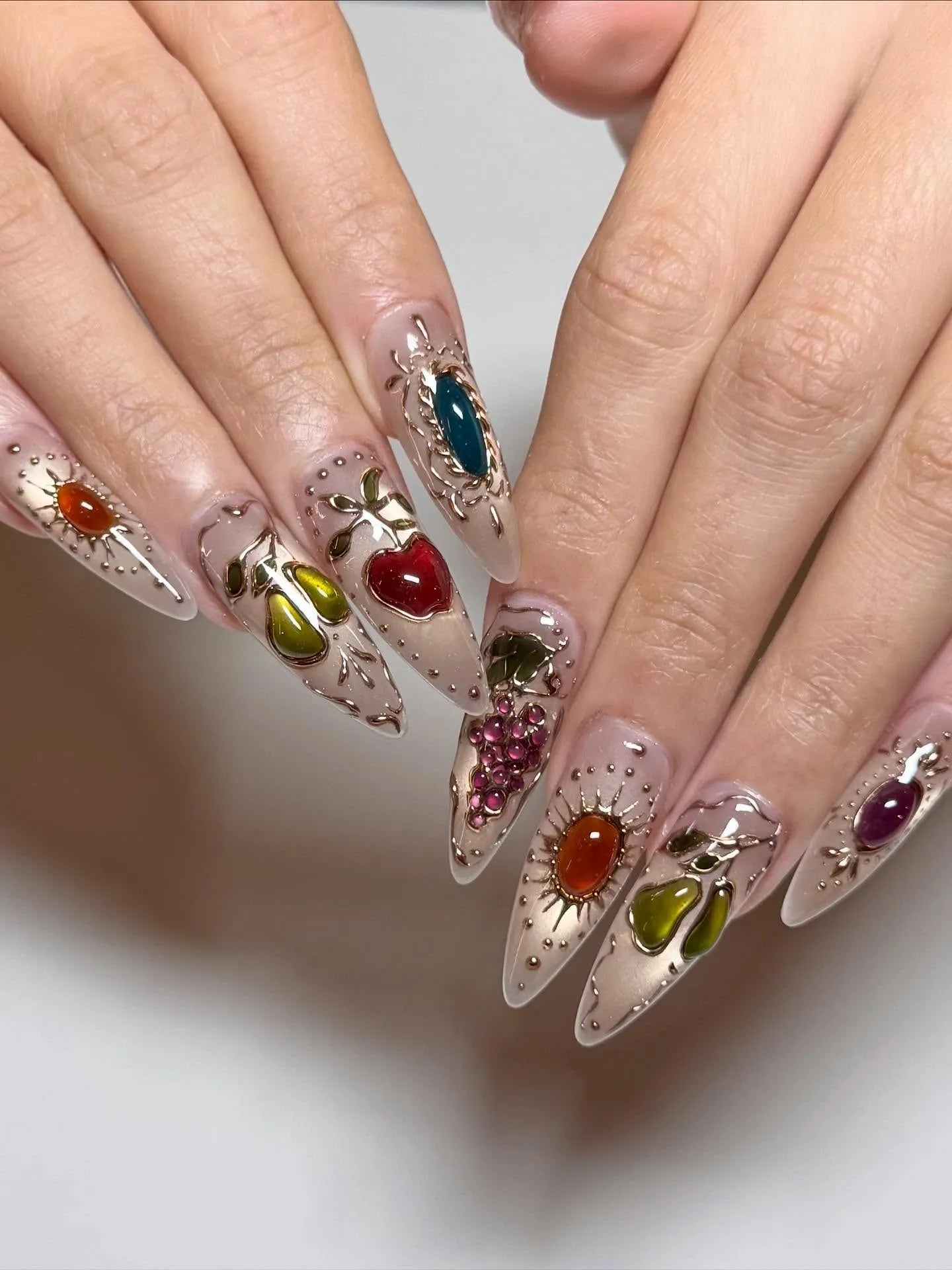 Handmade stiletto press-on nails with gemstone fruit designs and gold filigree accents