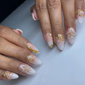 Handmade white press-on nails with 3D floral, pearl, and gold accents for weddings.