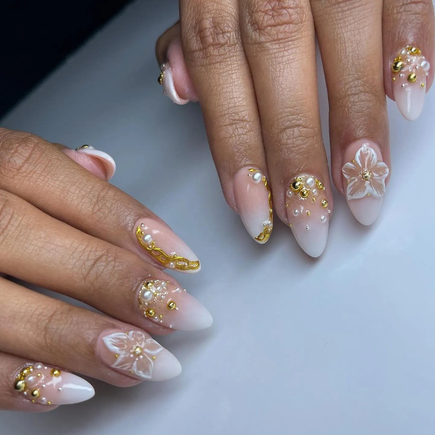 Handmade white press-on nails with 3D floral, pearl, and gold accents for weddings.