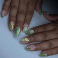 Handmade sage green press-on nails with butterfly, floral, and leaf 3D designs.