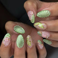 Handmade sage green press-on nails with 3D floral, butterfly, and leaf designs.