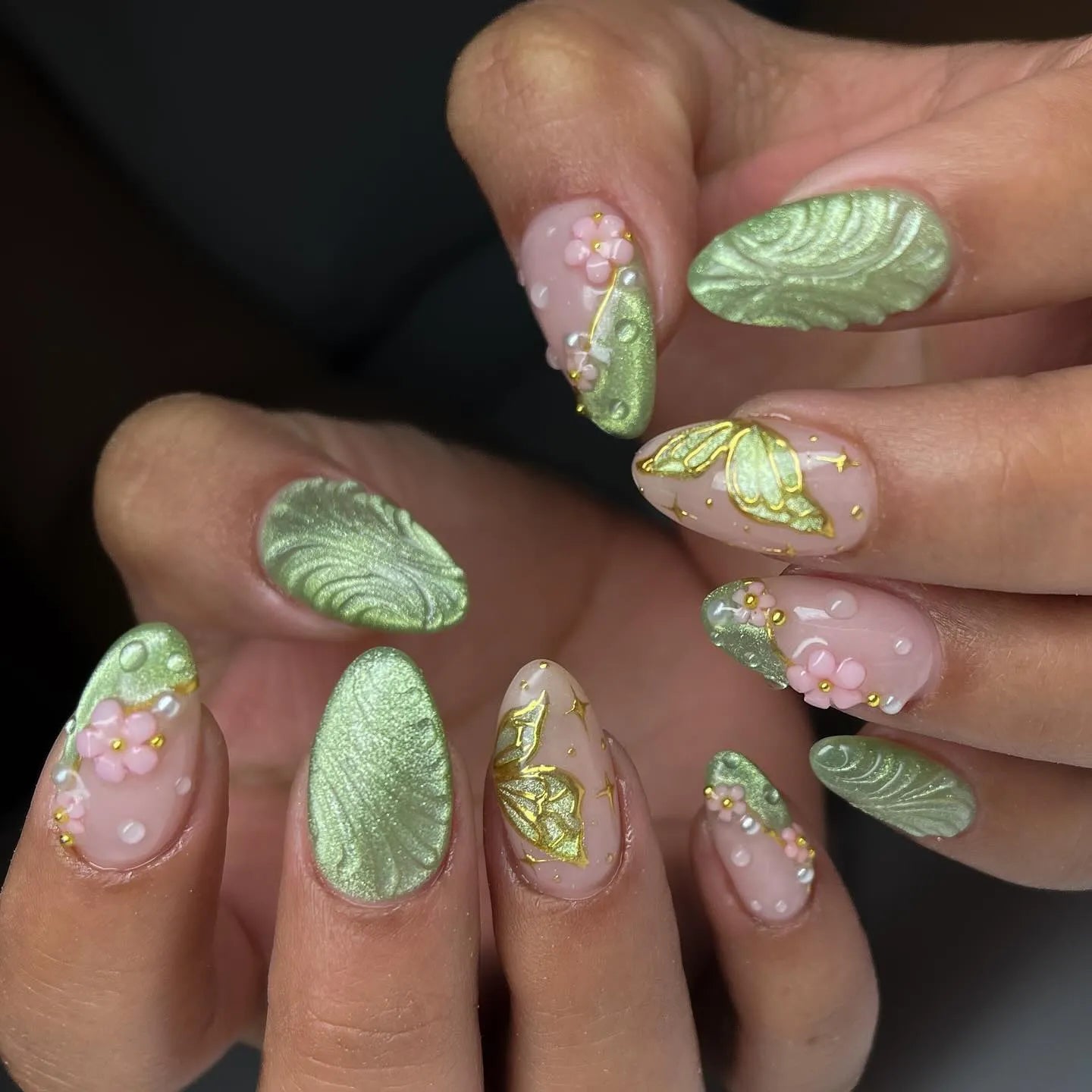 Handmade sage green press-on nails with 3D floral, butterfly, and leaf designs.
