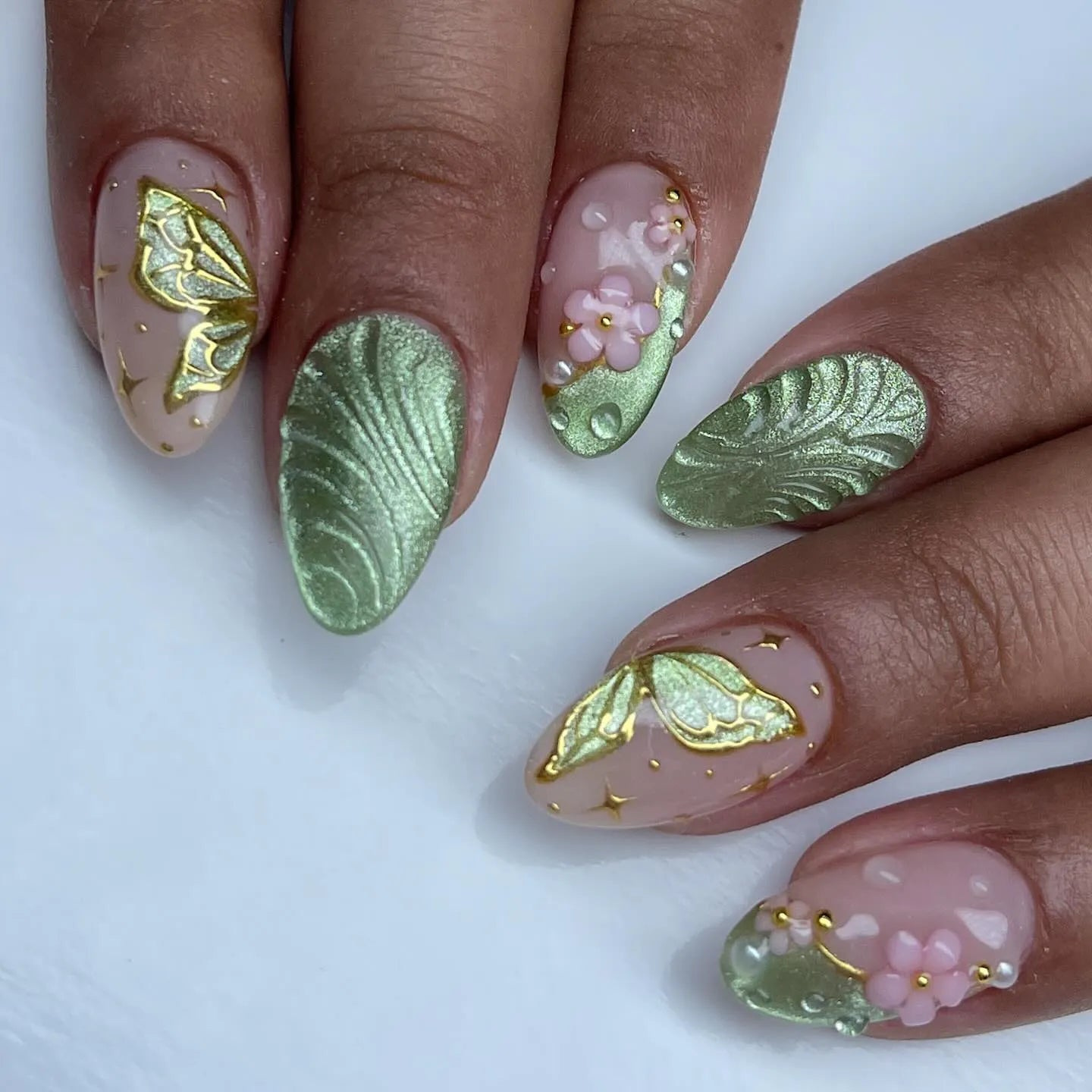 Handmade sage green press-on nails with butterfly and floral 3D designs.