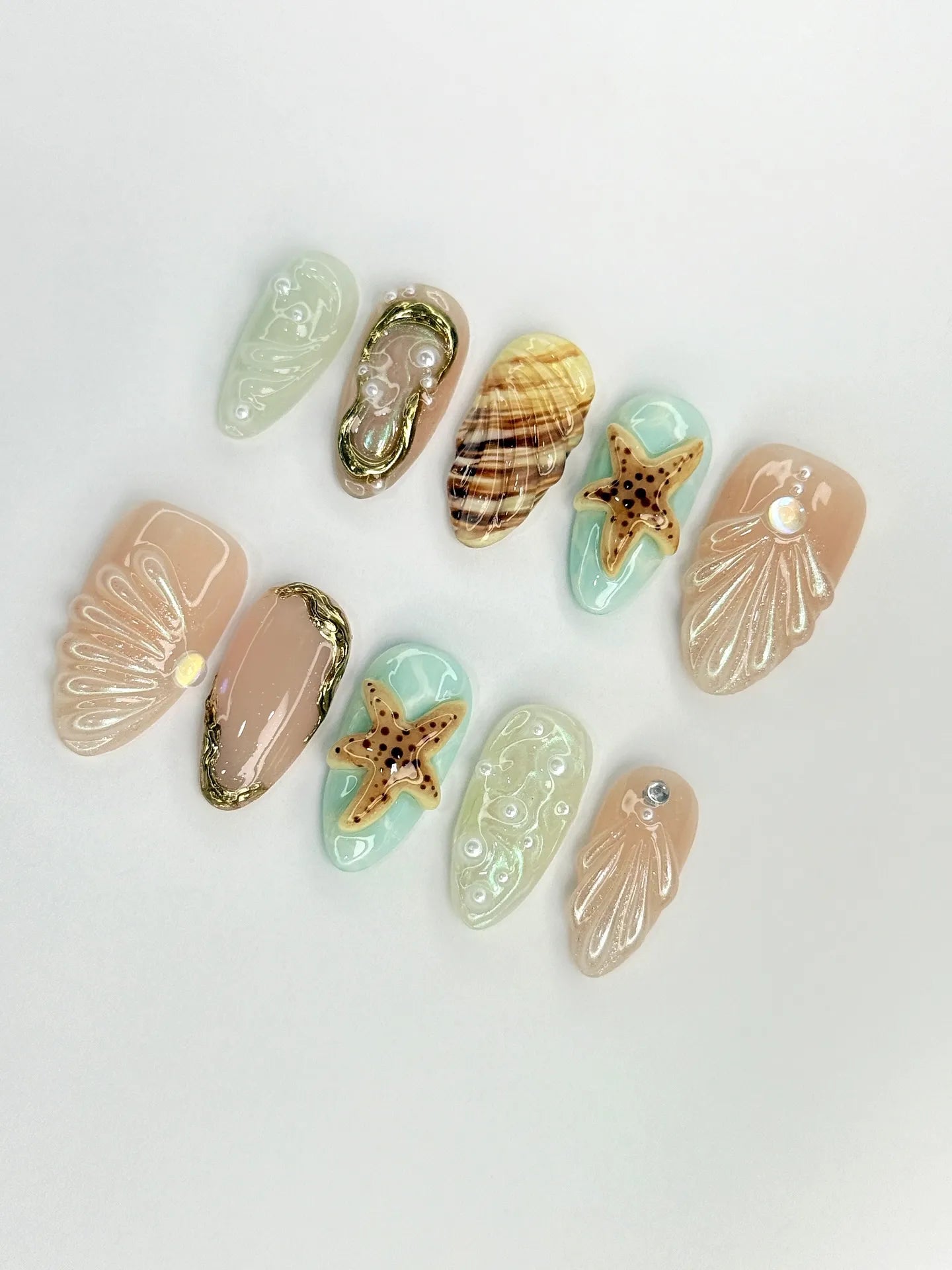 Handmade ocean-themed press-on nails with seashell, starfish, and pearl 3D designs.