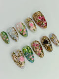 Handmade press-on nails with pink floral designs and rose gold filigree accents