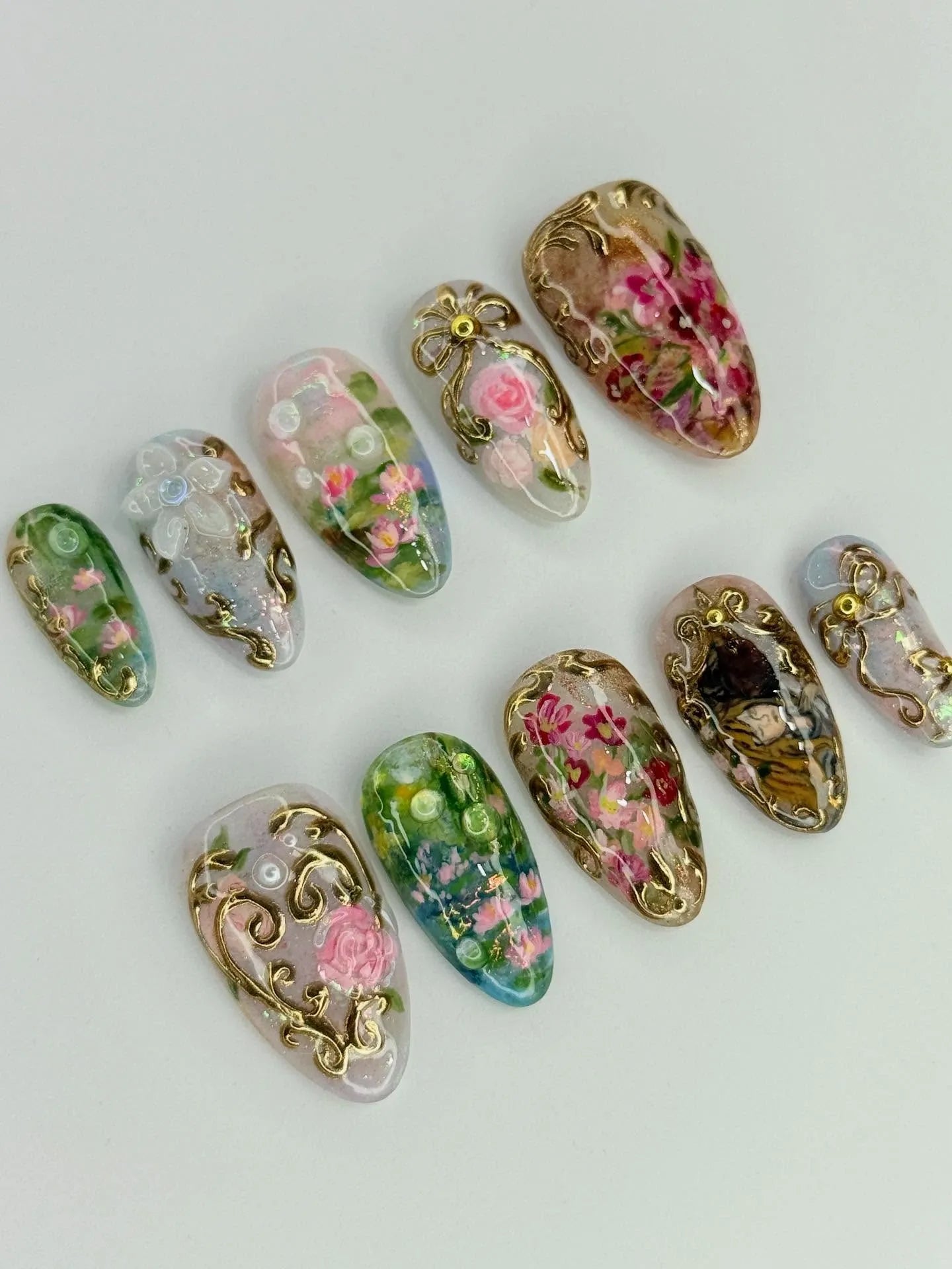 Handmade press-on nails with pink floral designs and rose gold filigree accents