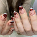 Handmade press-on nails with silver glitter French tips and metallic red ribbon bow design.