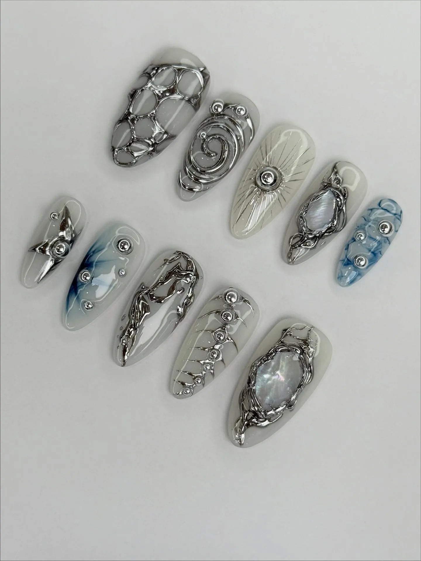 Handmade silver metallic cyber shell liquid chrome press-on nails set on white background