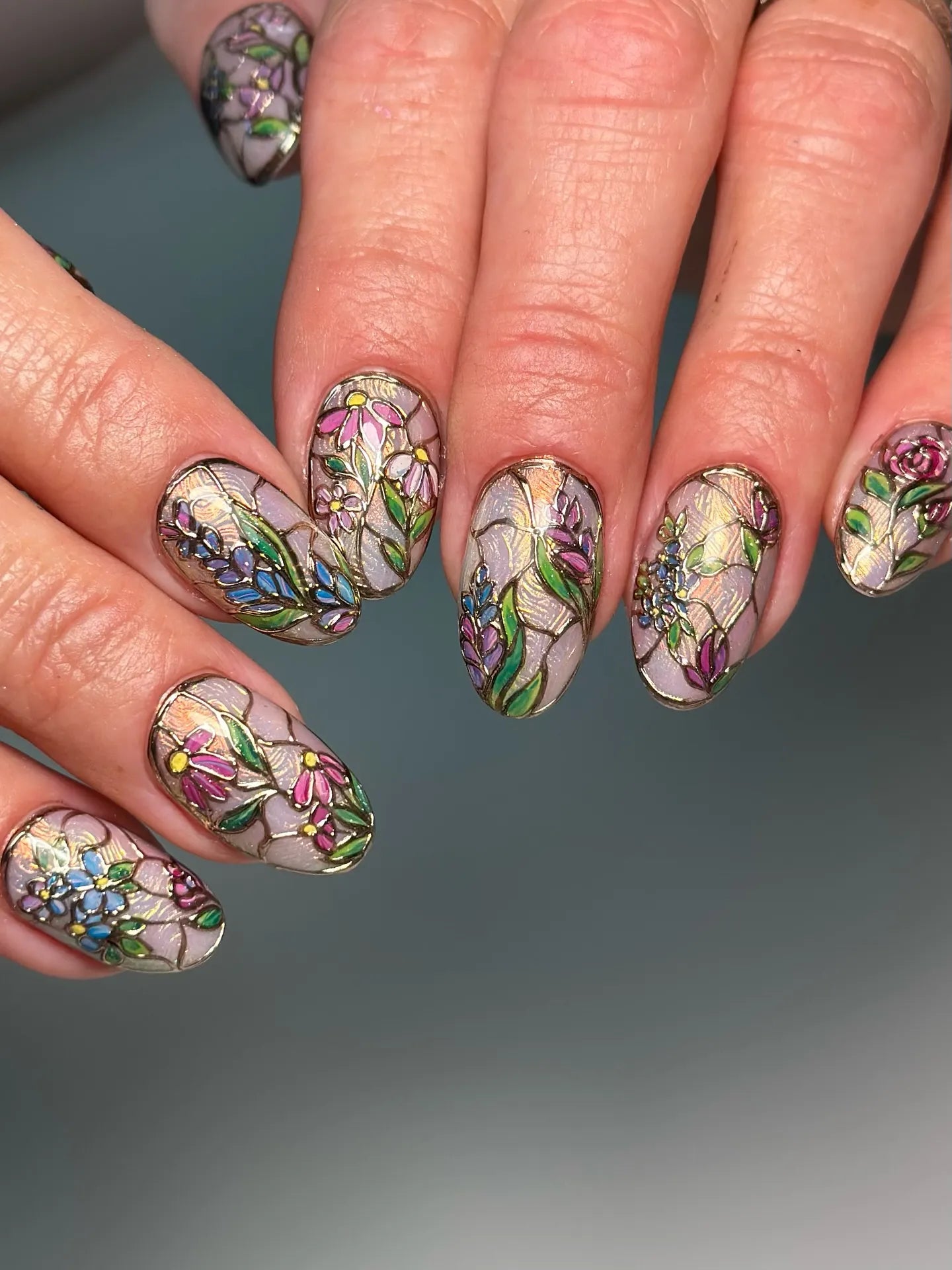 Handmade press-on nails with intricate stained glass floral design in pastel colors