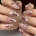 Handmade press-on nails with pink base, strawberry art, white lace accents, and pearl details