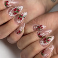 Handmade press-on nails with strawberry art, white lace French tips, and pearl accents.