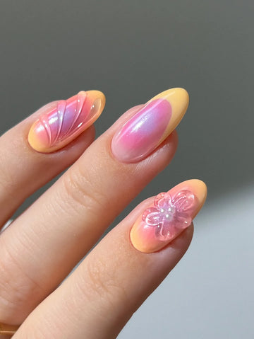 Handmade press-on nails with sunset orange and pink ombre, abstract art, and 3D flower design.