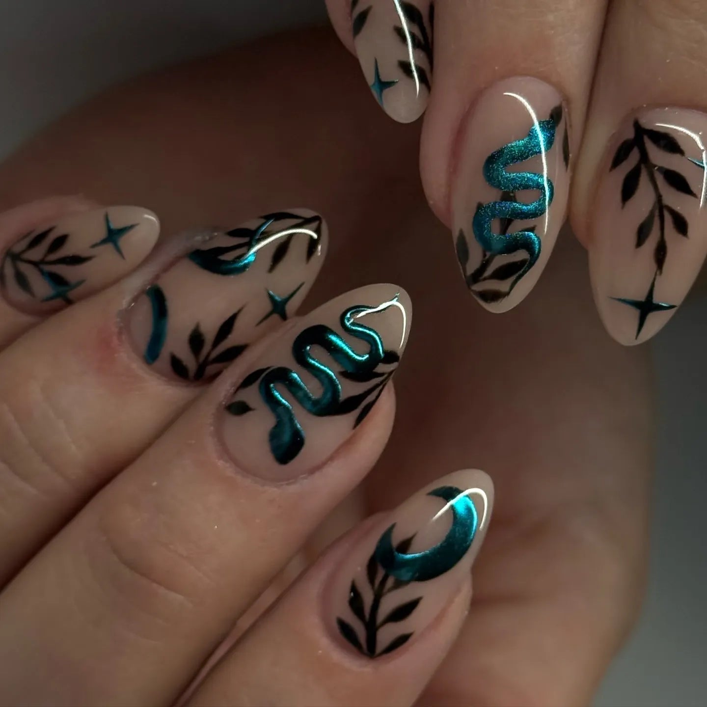 Handmade press-on nails with teal chrome snake, moon, stars, and black leaf gothic designs