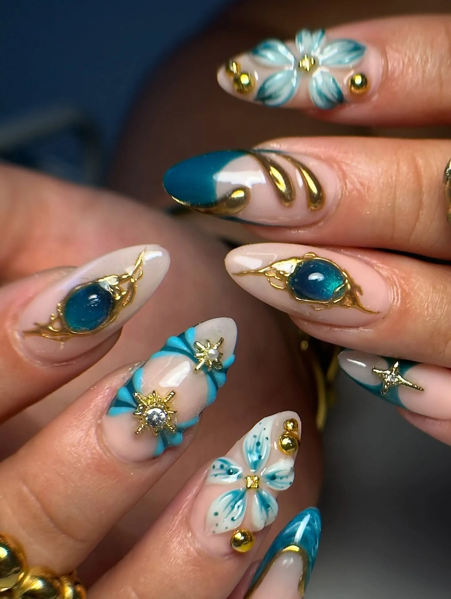 Handmade press-on nails with teal and gold 3D floral, celestial, and jewel designs
