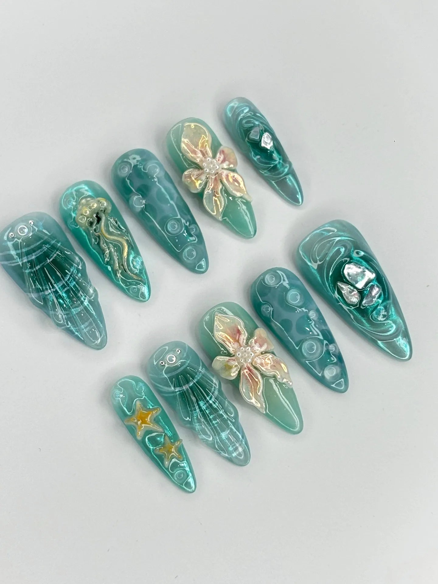 Handmade teal shimmer 3D press-on nails with jellyfish, starfish, and ocean shell designs