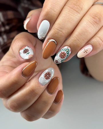 Handmade terracotta press-on nails with lace, floral, and artisan designs in earthy tones.