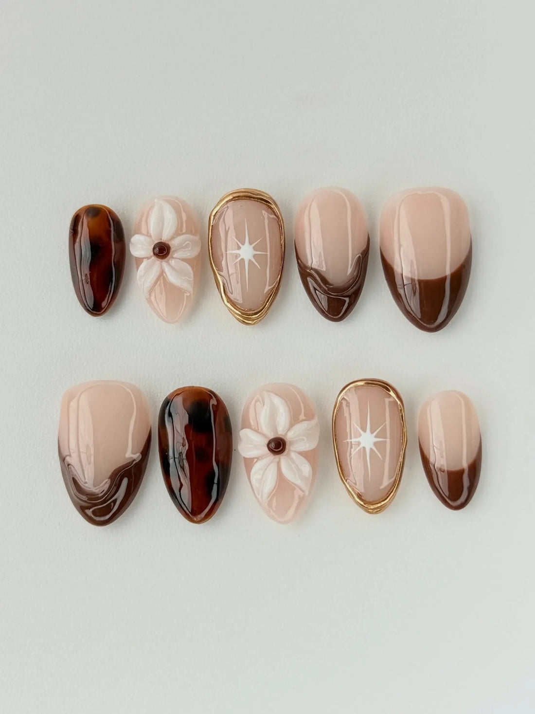 Handmade press-on nails with tortoise shell, 3D floral, brown French tips, and gold accents.