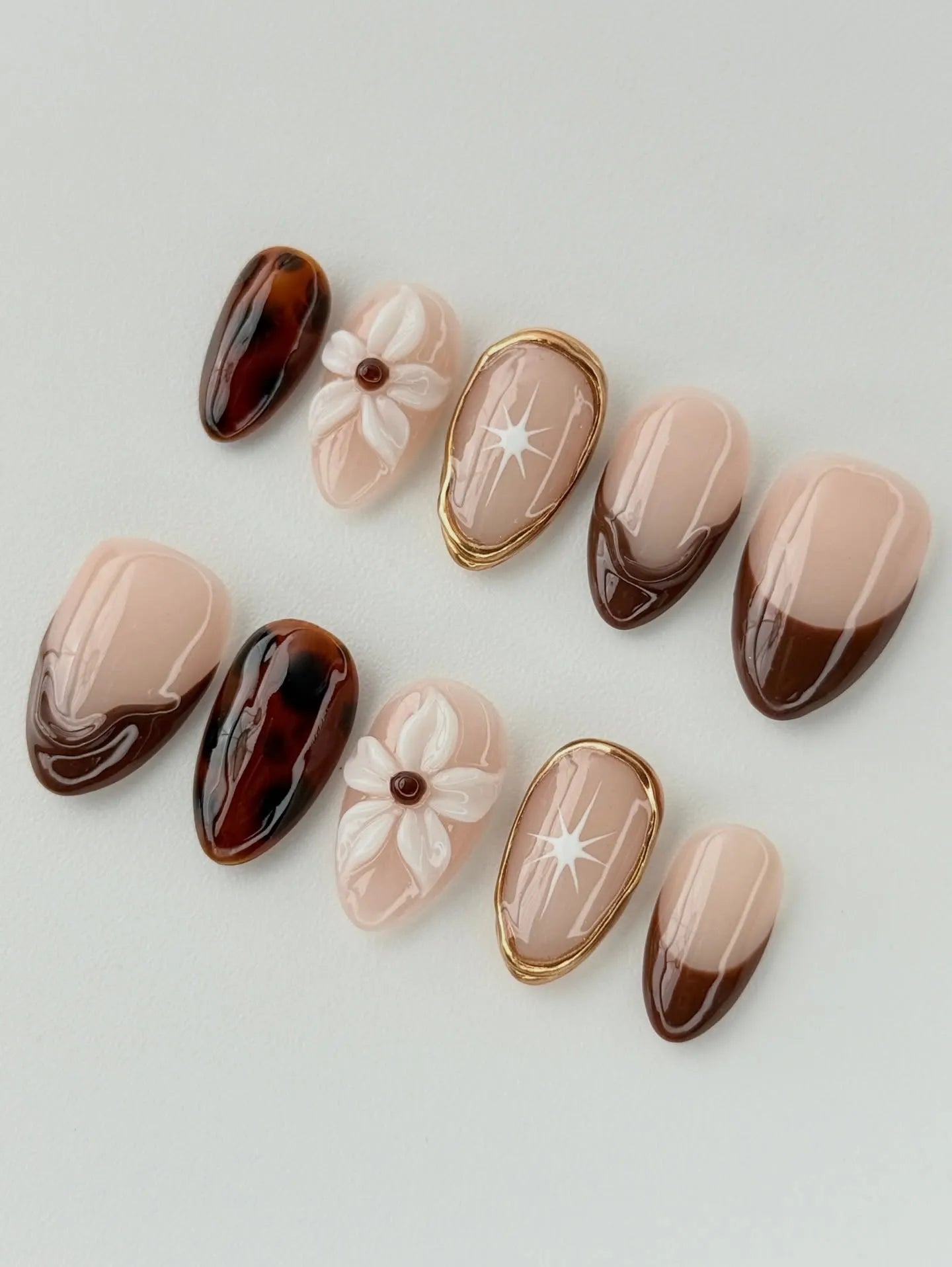 Handmade press-on nails with tortoise shell, 3D floral, and brown French tip designs