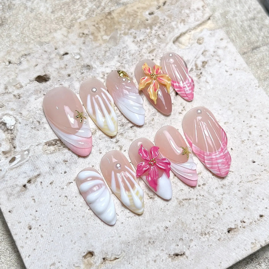 Handmade tropical press-on nails with 3D shell and hibiscus flower designs in pink and white.