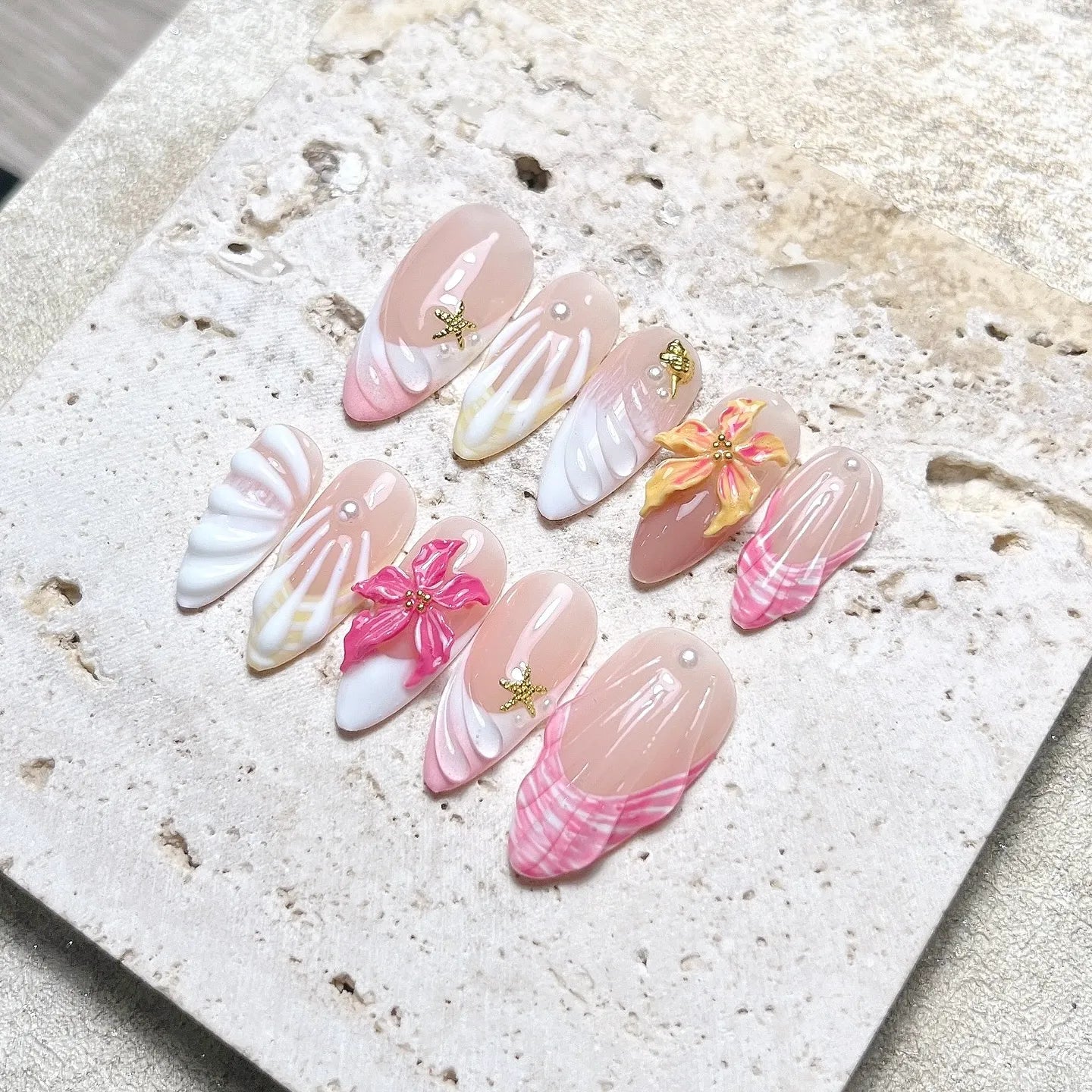 Handmade tropical press-on nails with 3D shell and hibiscus flower designs in pink and white.