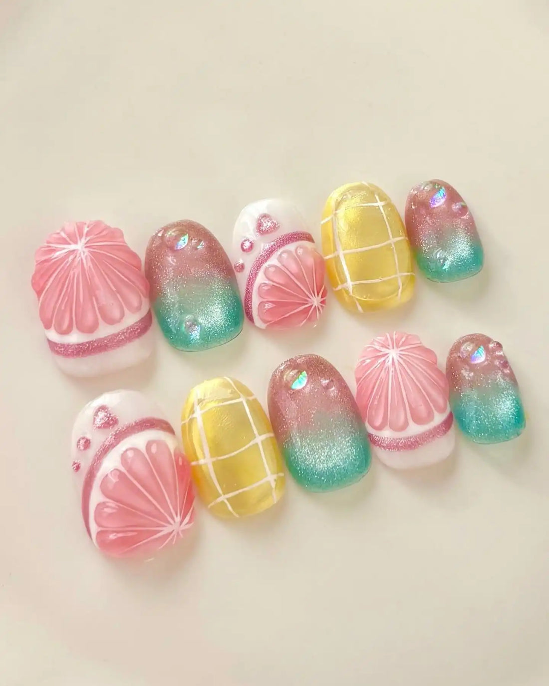 Handmade press-on nails with tropical fruit gradient, yellow grid, and shimmering summer design