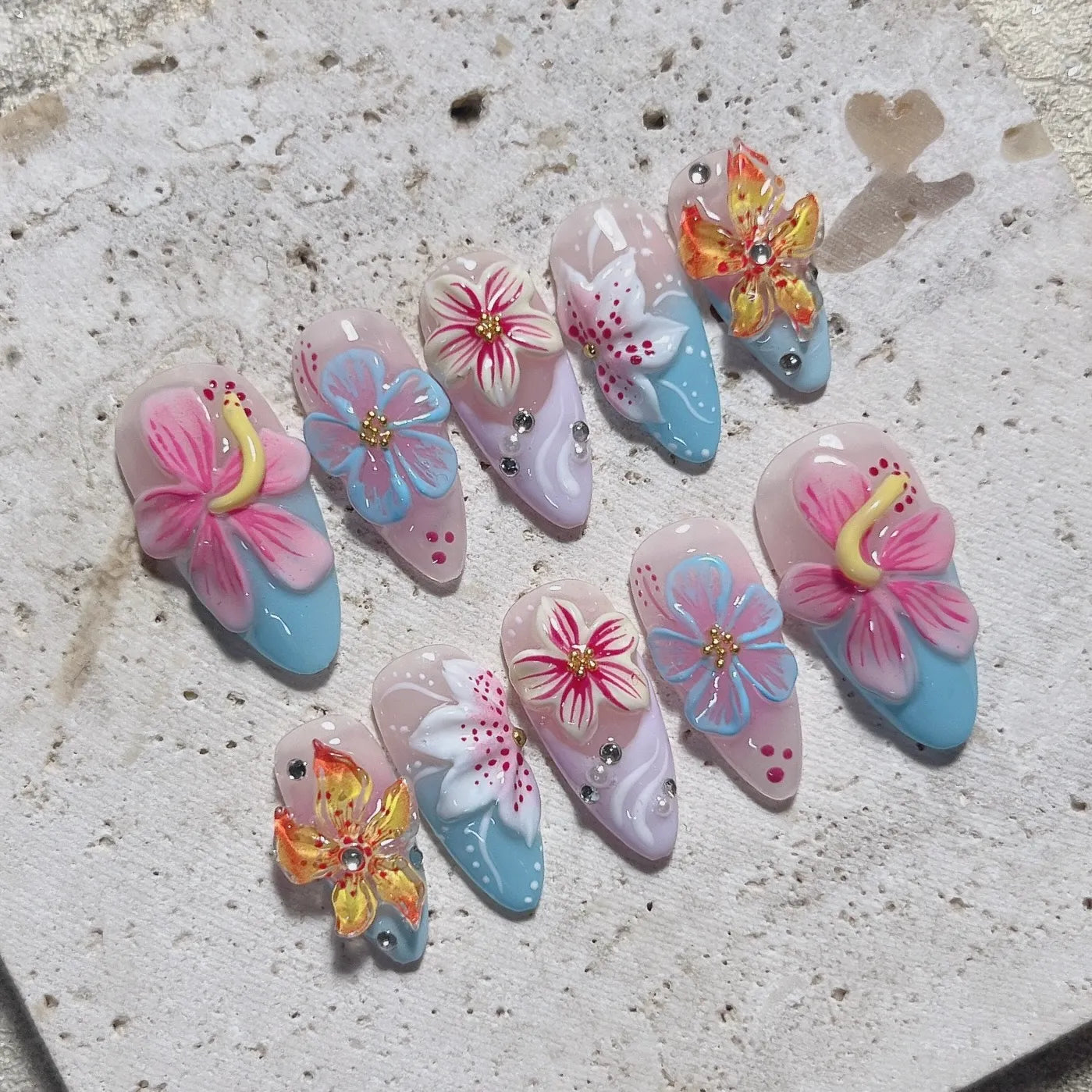 Handmade press-on nails with 3D tropical hibiscus floral designs in bright summer colors.