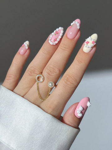 Hand with pink and white 3D rose pearl coquette press-on nails, delicate floral design