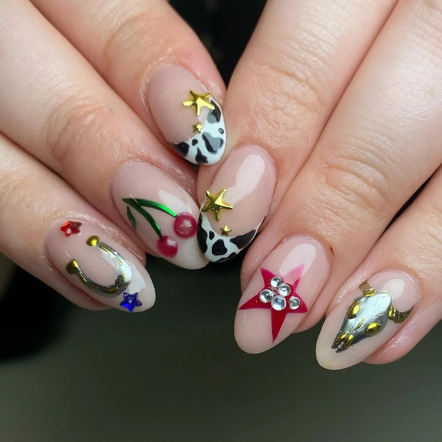 Handmade press-on nails with cow print, cherries, horseshoe, western stars, and skull designs