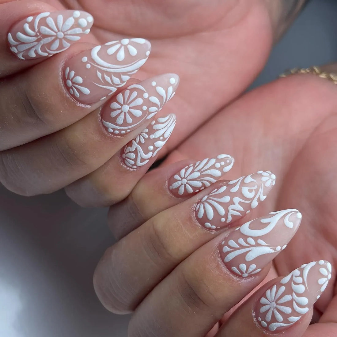 Handmade white lace floral swirl press-on nails with elegant bridal nail art.