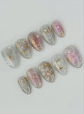 Handmade press-on nails with white pearls, gold crescent moon, stars, and floral accents.