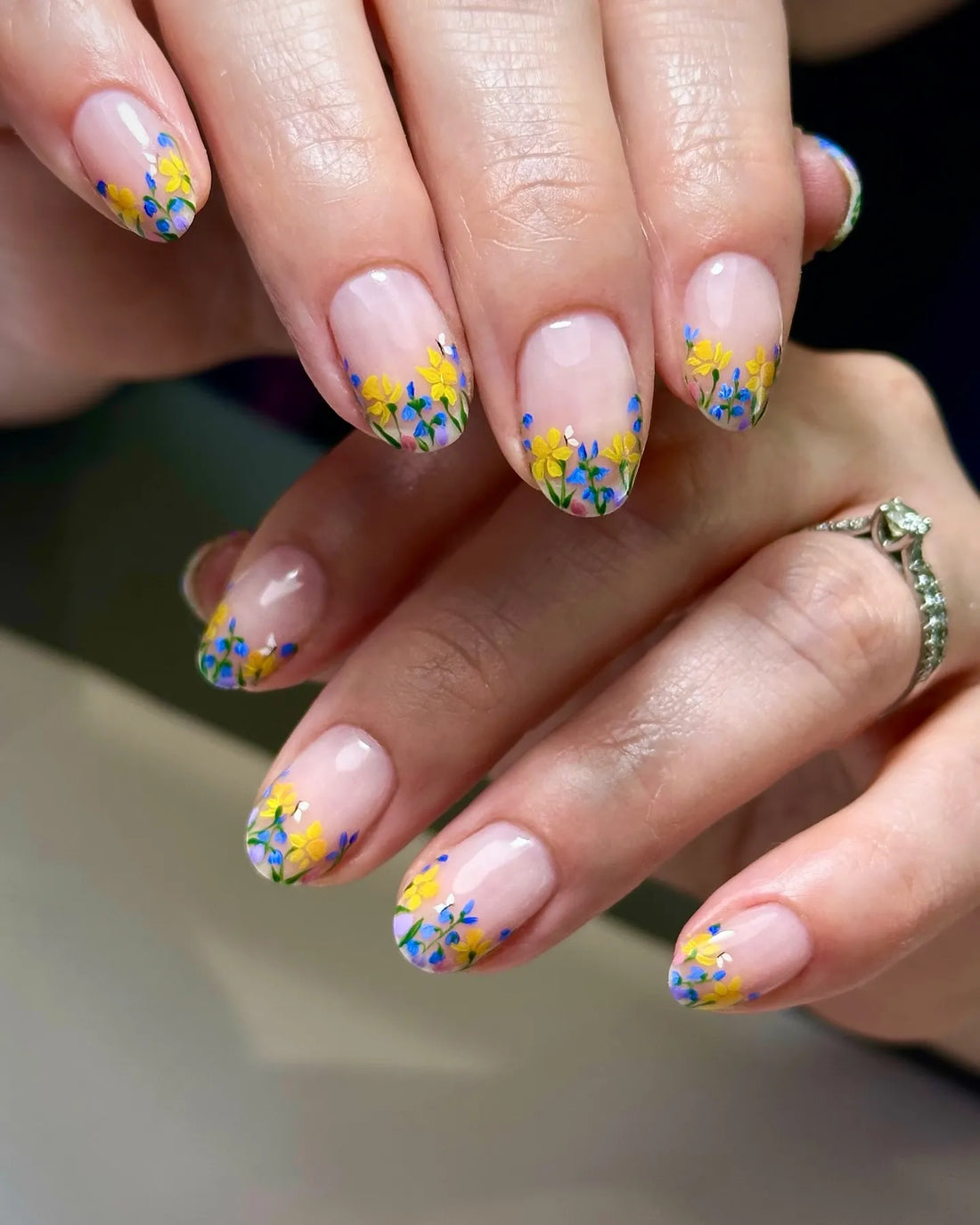Handmade press-on nails with clear base and yellow and blue wildflower French tips