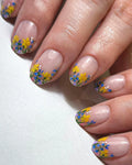 Handmade press-on nails with clear base and colorful wildflower French tips