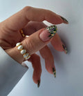 Hand with handmade press-on nails featuring white French tips and wildflower meadow floral design