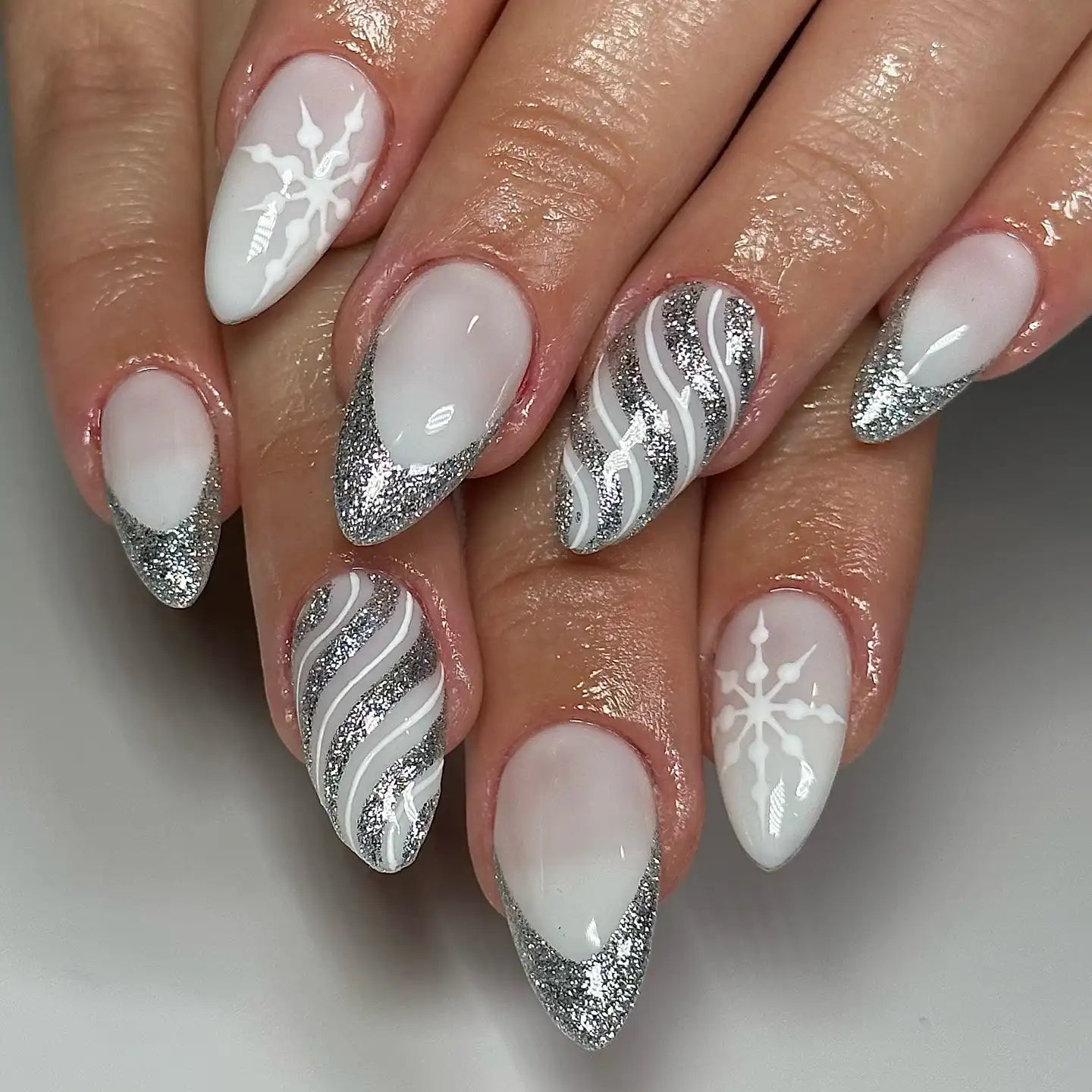 White winter nails with silver glitter stripes and snowflakes
